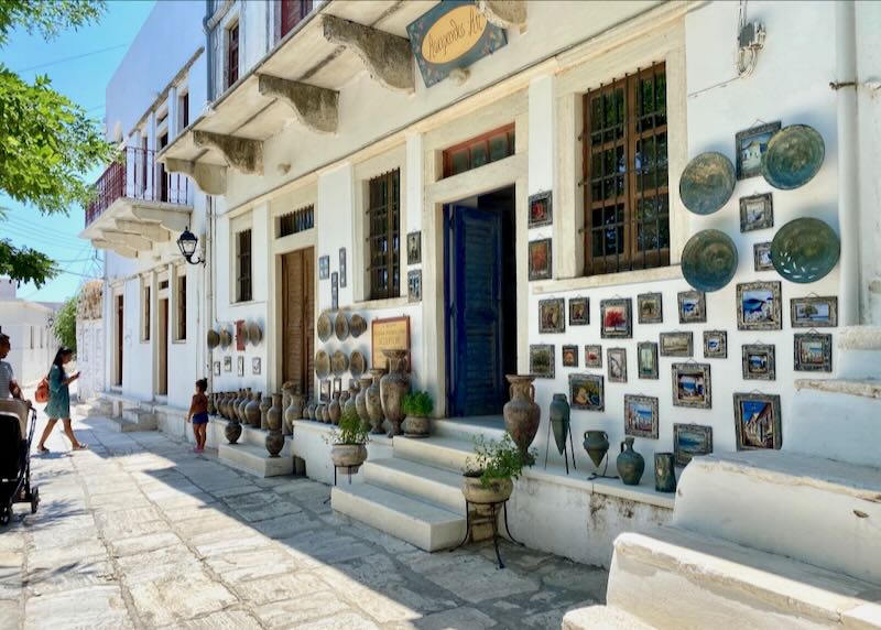 White marble sidewalk leading past a pottery studio in a mountain village.