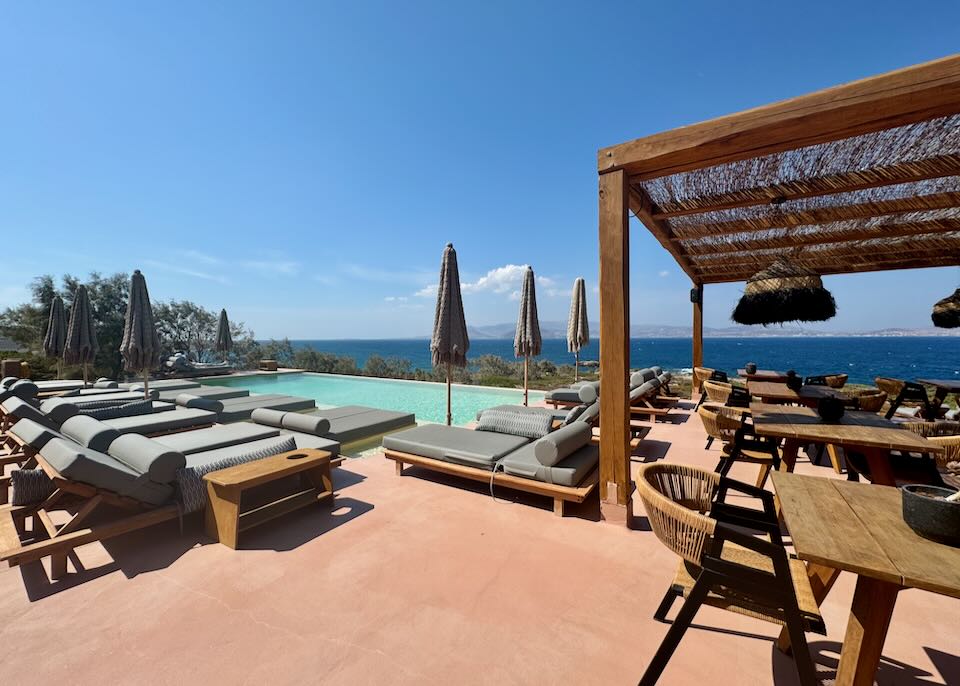 Pool and sun chairs with a pool bar overlooking the sea.