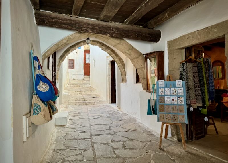 Stone footpath in an old castle, with a weaving shop to one side.