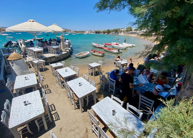 Restaurant with tables set in the sand right up to the water's edge.