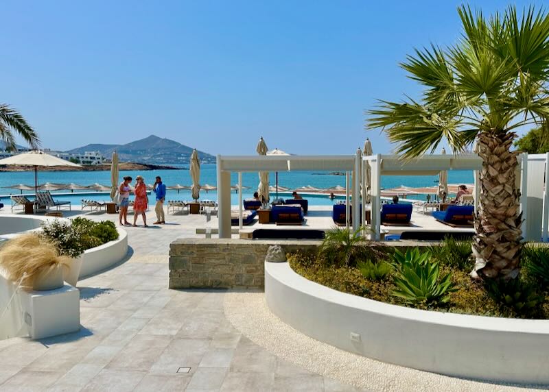 View looking past an umbrella-lined sun deck to the blue sea.