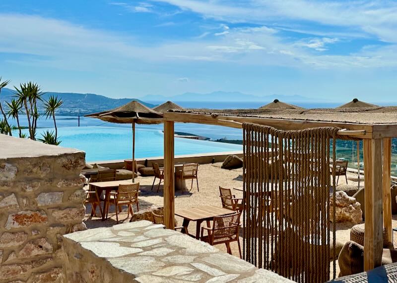 View over a luxury hotel pool terrace, surrounded by sand made to resemble a beach