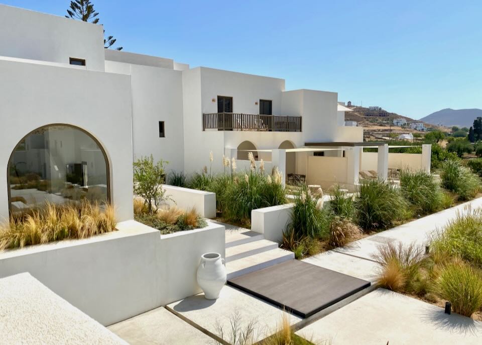 Boxy white hotel with Cycladic design and mediterranean landscaping