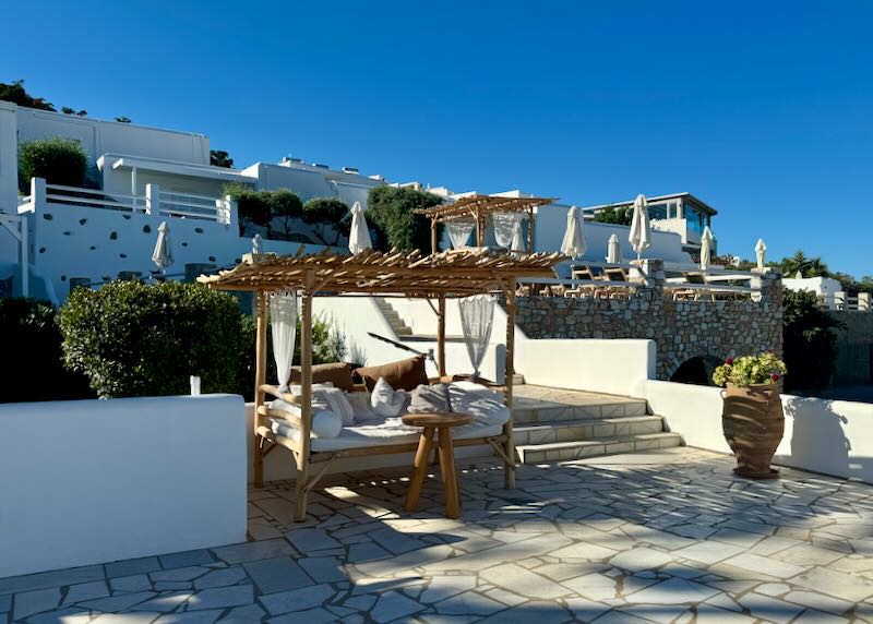 View looking up at a white Greek hotel that is terraced up a hillside.