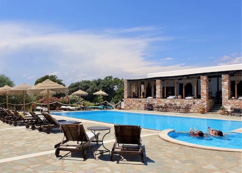 Two people lounge in a hotel pool on a sunny day