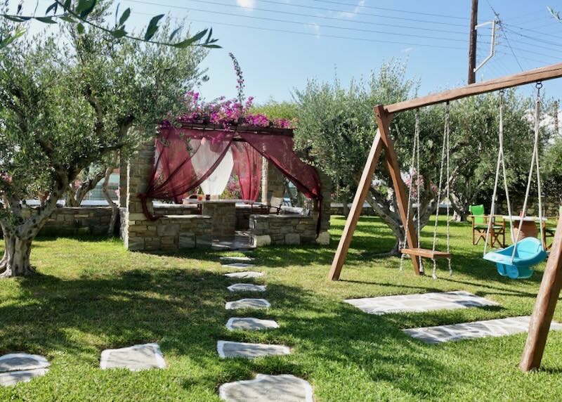 Grassy lawn with a small playground and a stone gazebo