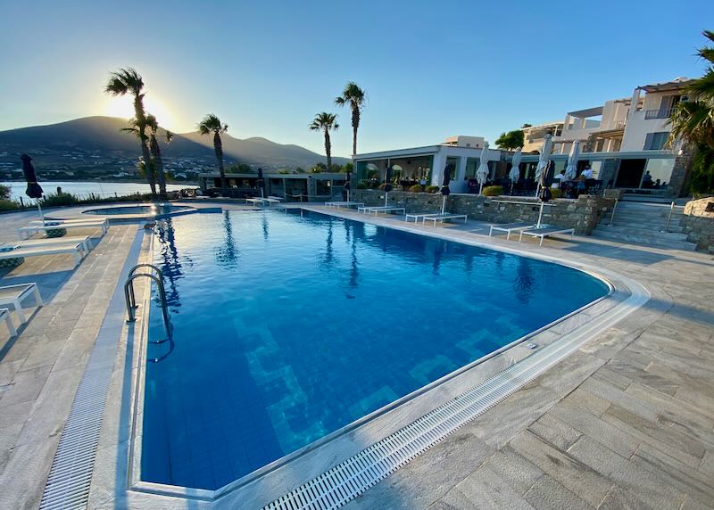 Hotel swimming pool with swaying palms at sunset