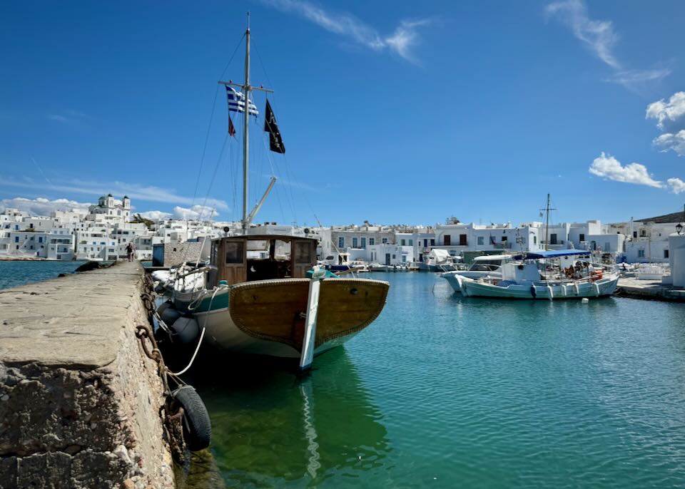 Boats in a harbor ringed by boxy white buildings.