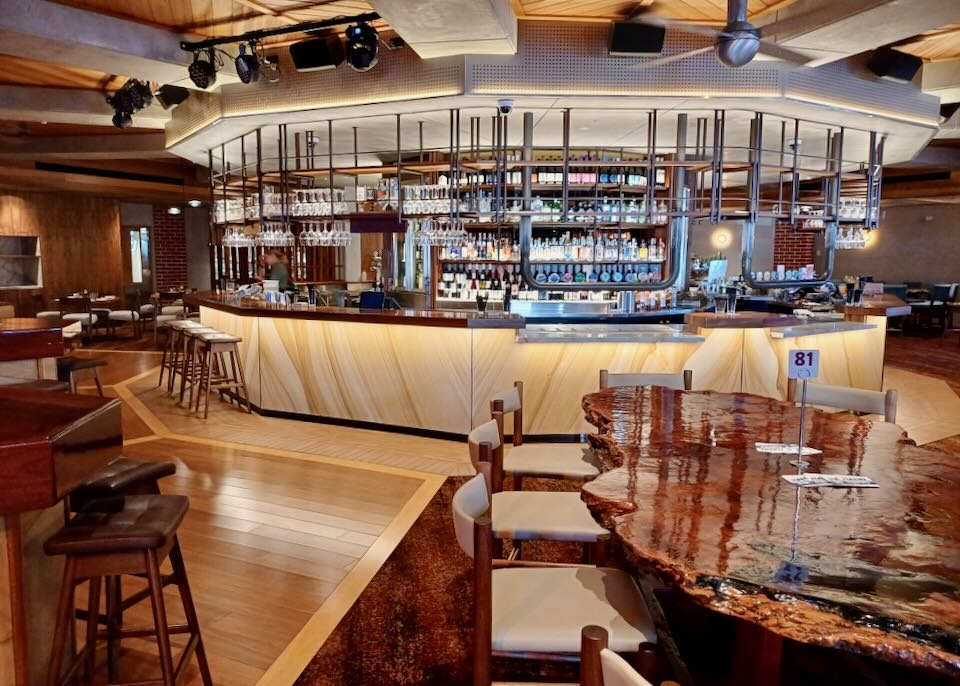 A wood round bar sits in a restaurant.