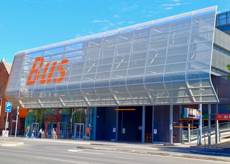 A metal gridded sign with "Bus" in bright orange.