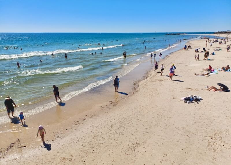 People wade in the ocean.