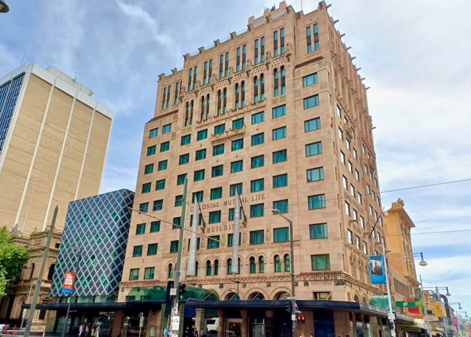 A tall 10-story building with tan brick and blue windows.