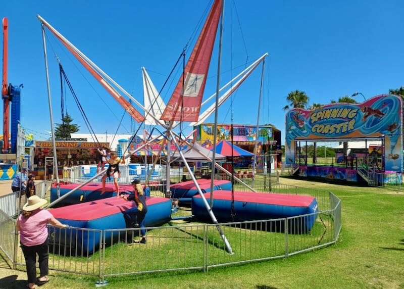 A child sits in a sling waiting to bounce herself high up in the sky.