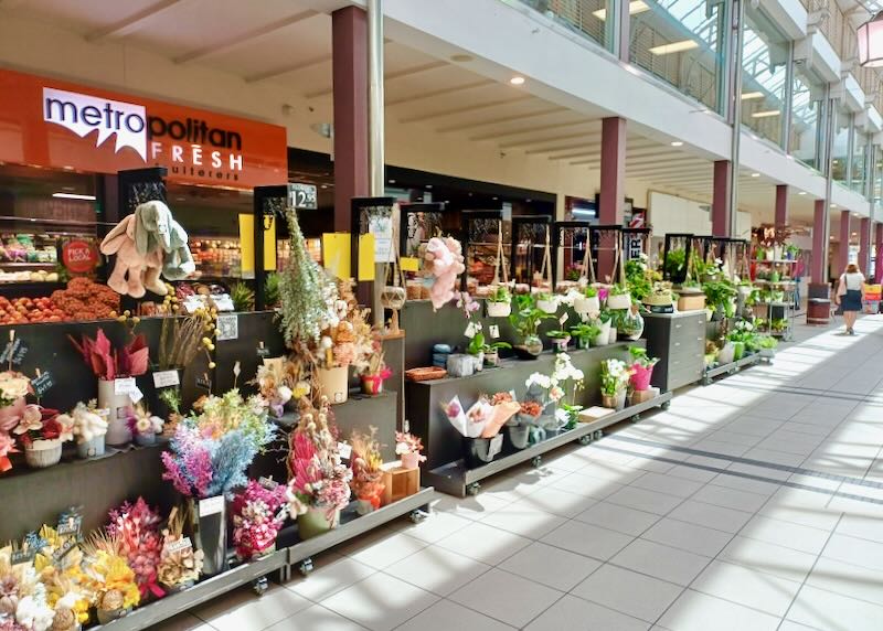 The outside of a store showcasing bouquets of flowers.