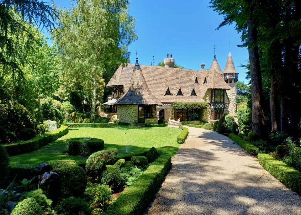 A castle sits in lush greenery.