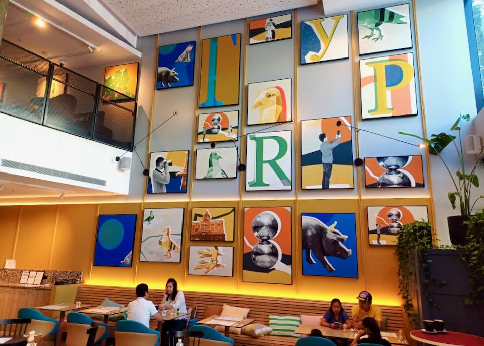 A cafe wall with blue, green, orange, and yellow letters and paintings.