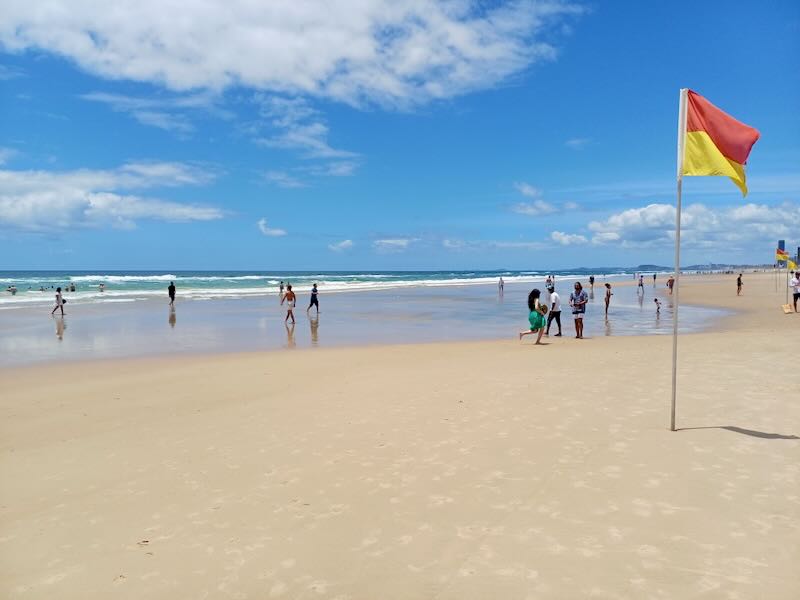 People walk on a wide beach.