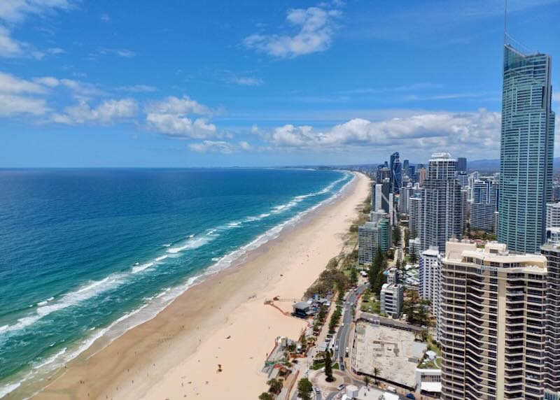 A view of sand and blue ocean from high up.