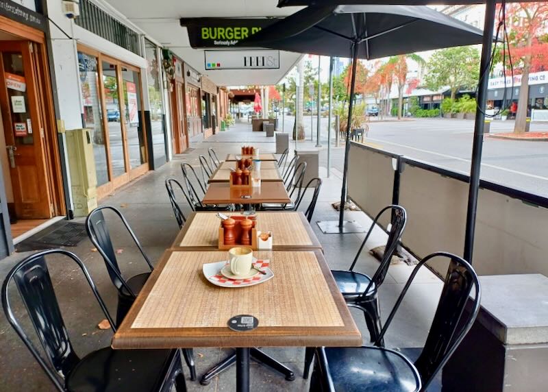 A row of tables line a sidewalk.