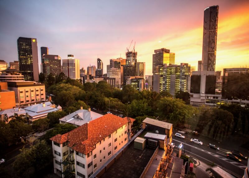 A sunset over a city with orange and purple light.