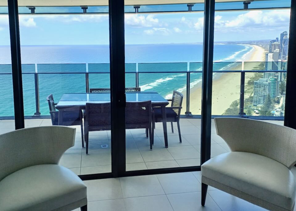 An outdoor deck with a table has ocean views.