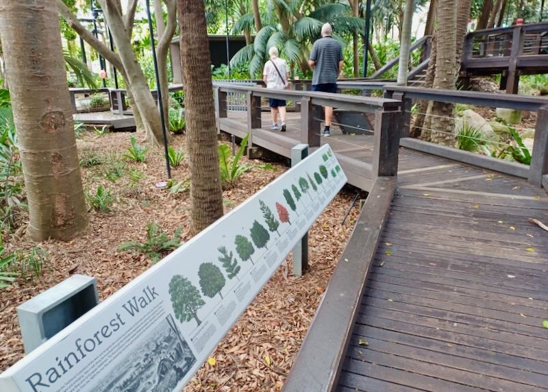 A couple walk along a wooden path.