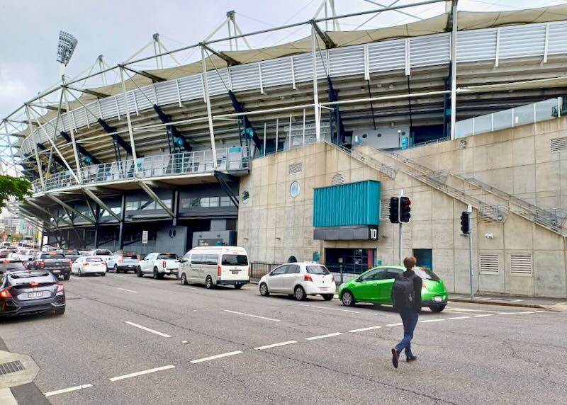 A large round stadium curves several stories above the street.