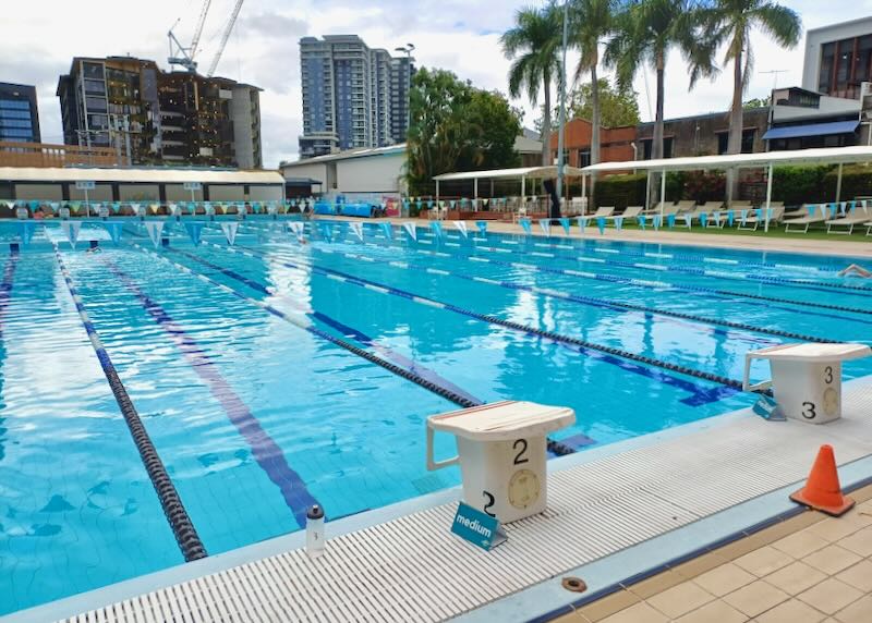 A long sports pool has diving platforms on the side.