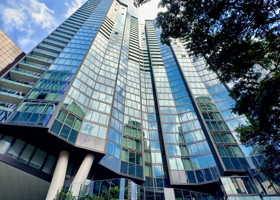 A tall building with windows reflecting the blue sky.