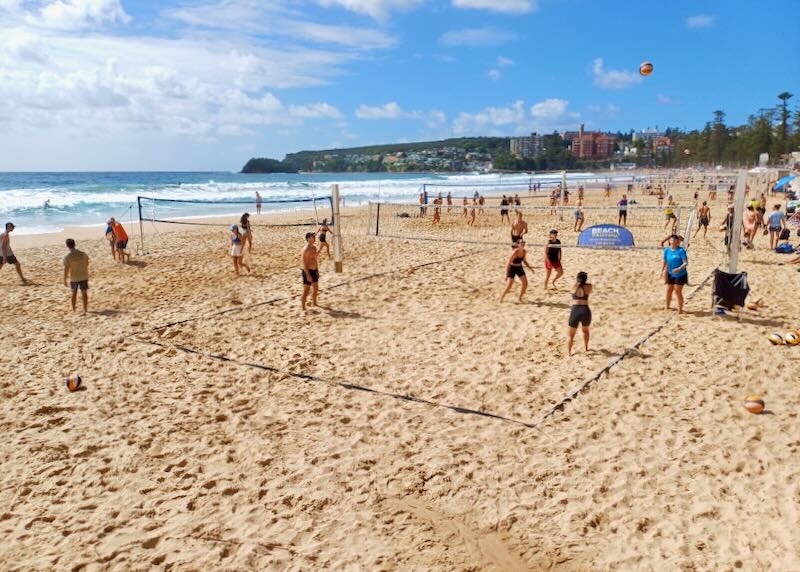 People play in rows of beach volleyball games down the shore.