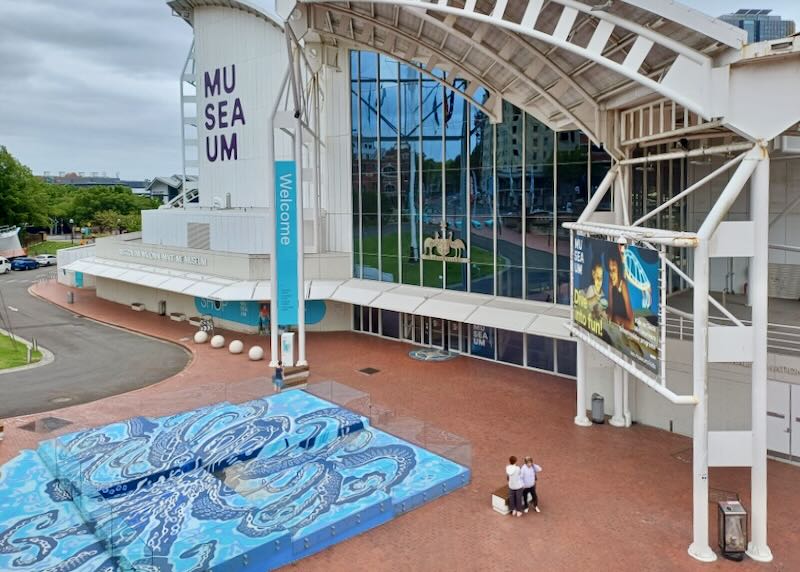 People sit outside a multi level museum.