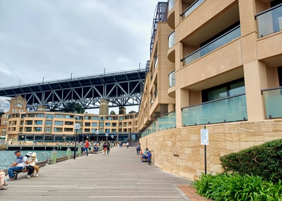 A pedestrian path sits along the water next to a hotel.