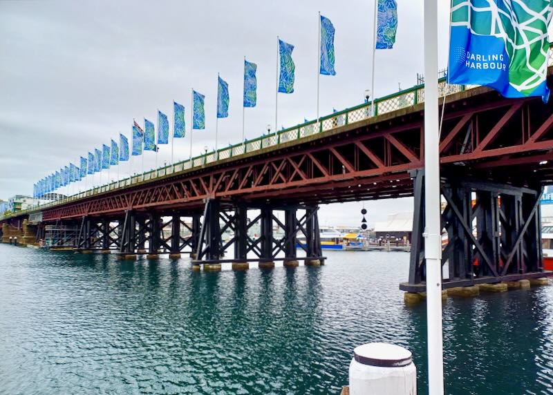 A walking bridge with blue flags.