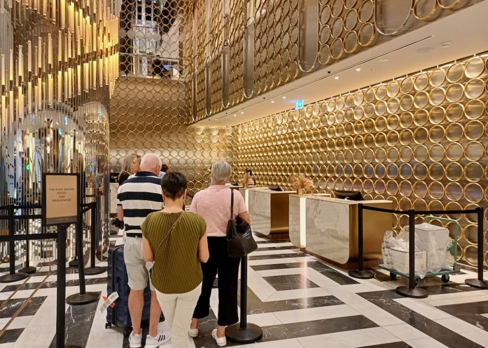 A hotel reception area filled with ceiling to floor gold rings.