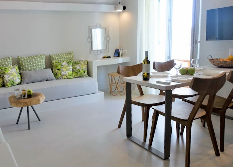 Contemporary table set with wine glasses and a bottle of wine in a light-filled room with built-in seating