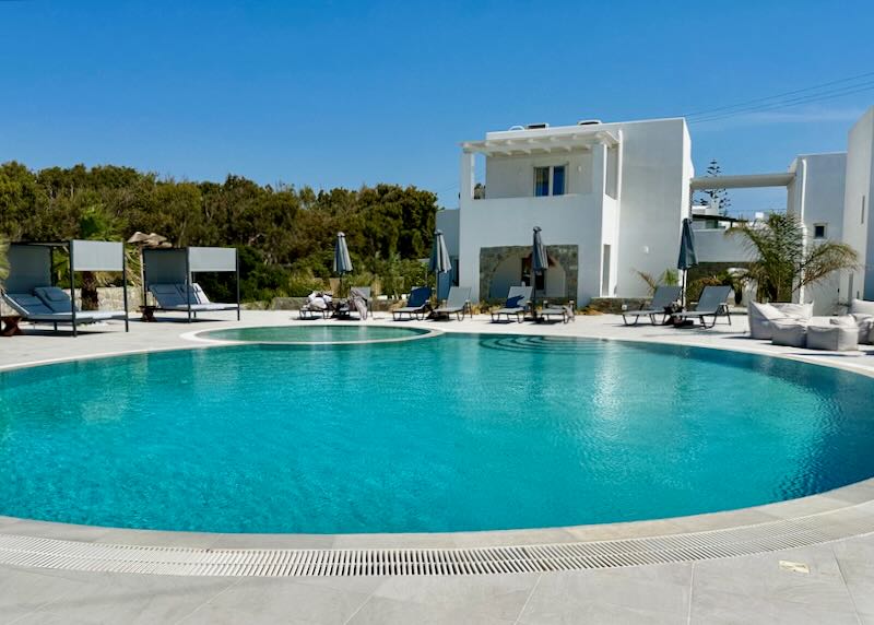 Large blue swimming pool at a white Cycladic-style hotel