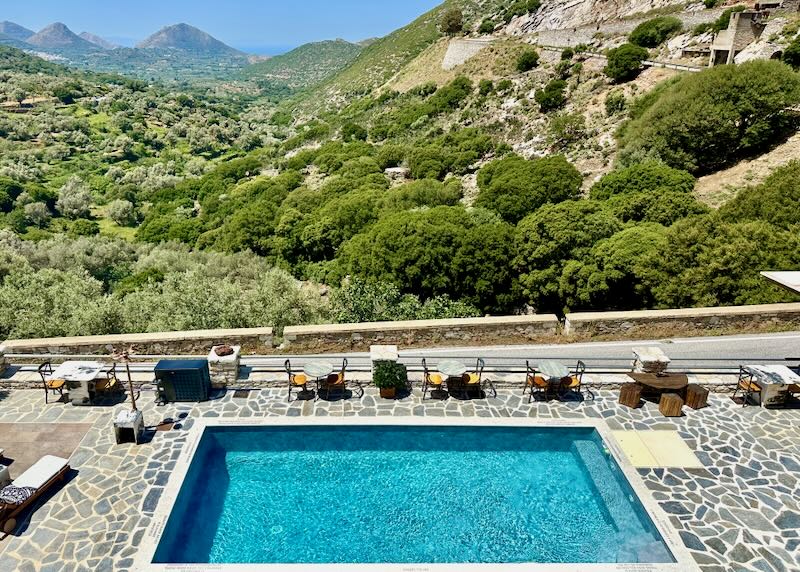 View over a stone swim terrace to a green mountainside.