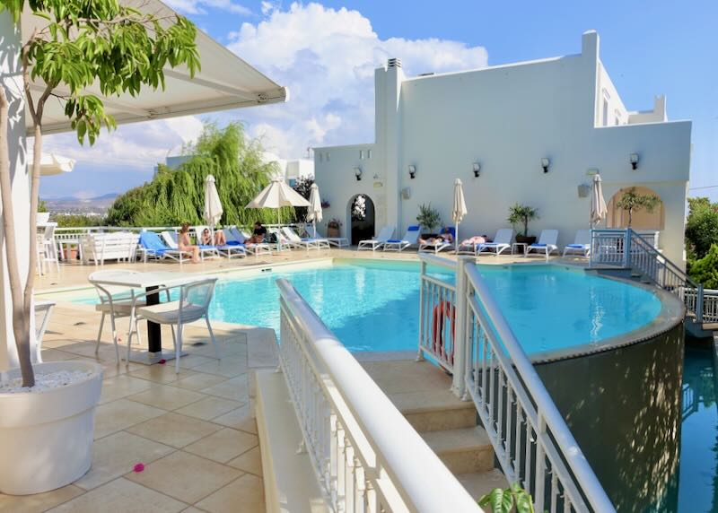 View up a stairway to a hotel rooftop swim deck with sun loungers