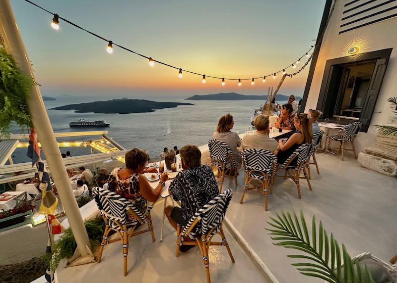 View of diners and the Santorini Caldera sunset at Marinera Restaurant in Fira.