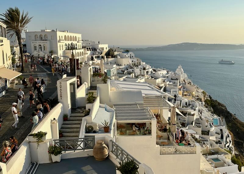 View of Fira village with the caldera, sea, and boats below in Santorini.