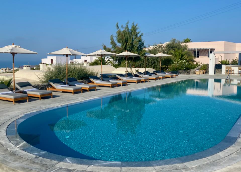 Hotel swimming pool in Greece, surrounded by sun loungers