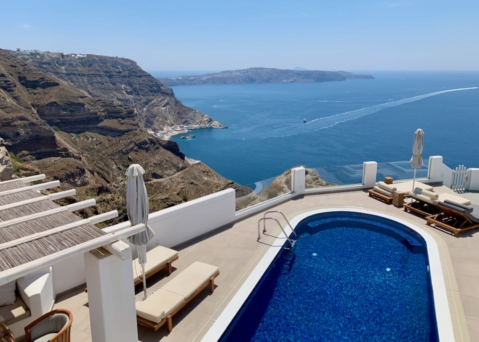 View over the Santorini caldera and Athinios port from a hotel swim deck.