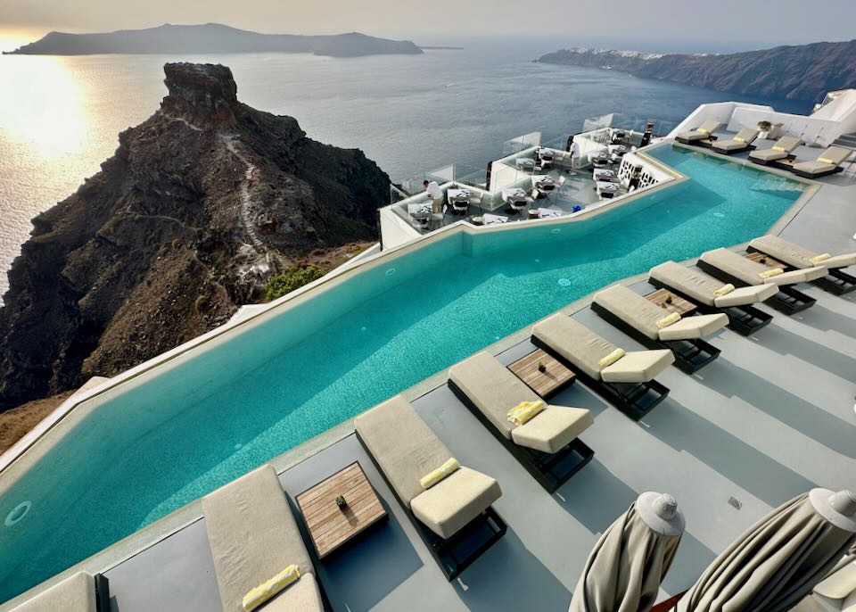 View over a hotel swimming pool to Skaros Rock and the Santorini caldera.