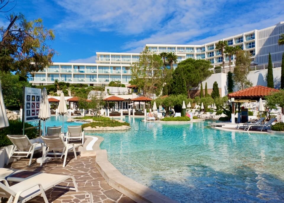 A large pool with lots of lounge chairs.