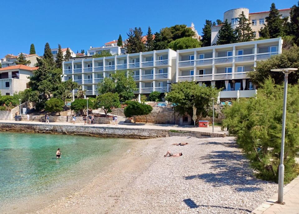 A hotel next to a pebble beach.