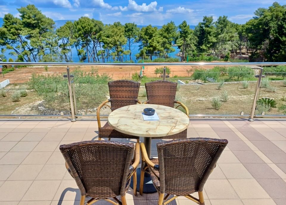 A table sits on a tile patio overlooking the sea.