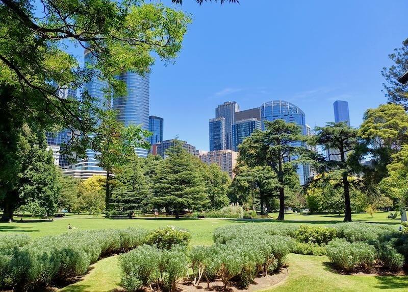 A grassy park has views of the city.