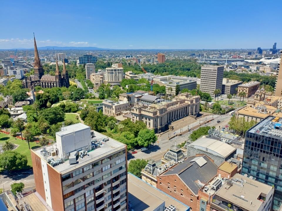 A view from hight up of a city, parks, and a mountain in the distance.