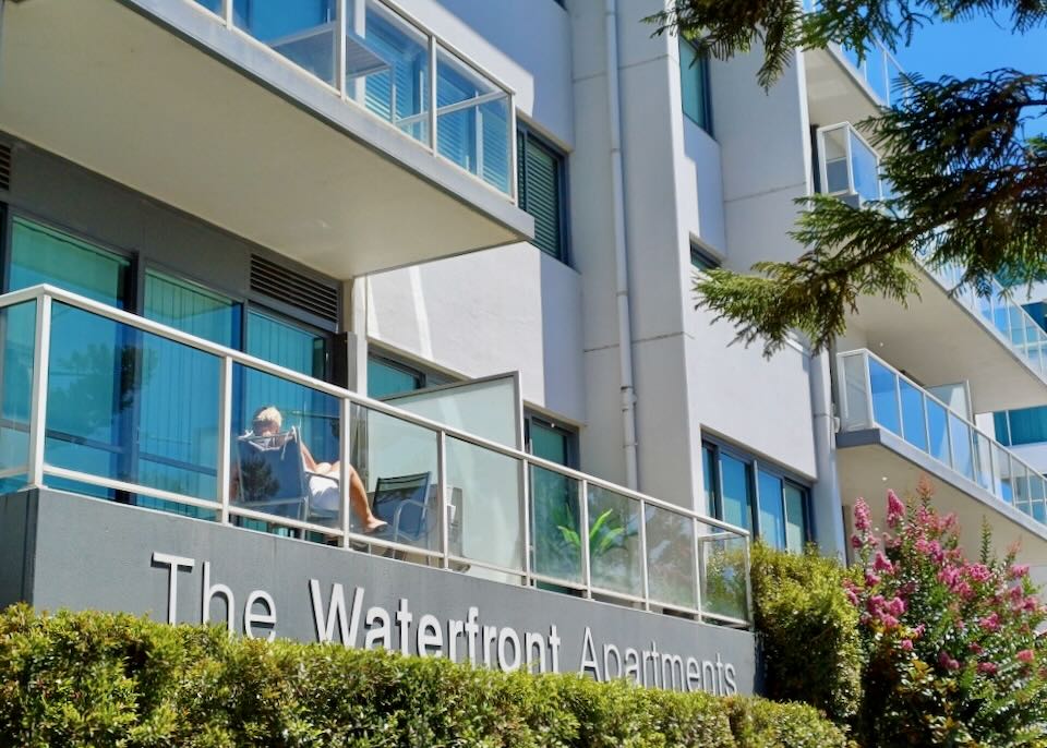 A woman sits on a balcony at a hotel.