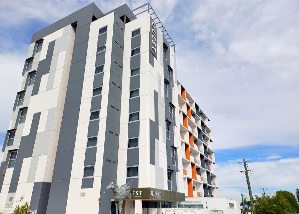 A tall hotel with a silver metal sculpture of a horse.